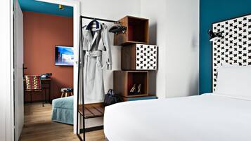 A hotel room with a bed, a wardrobe, a TV, a chair, and a desk.