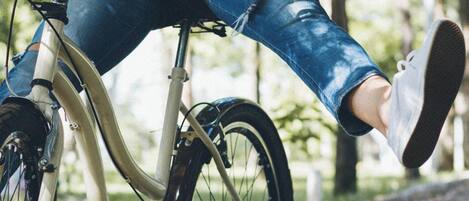 A person riding a bicycle on a leaf-covered path.