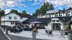 Un restaurant avec une terrasse, une enseigne indiquant « VEGGI VERTSHUS » et une autre indiquant « ROM - KAFE - RESTAURANT ».