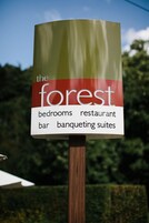 Un letrero que dice 'The Forest' y anuncia habitaciones, restaurante, bar y salones de banquetes.