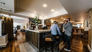 Una cocina moderna con una isla central, suelo de madera y una zona de bar.