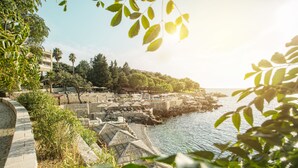 A coastal resort with stone walls, outdoor seating, and a view of the sea. - Radisson Resort Ruza Vjetrova (Bar)