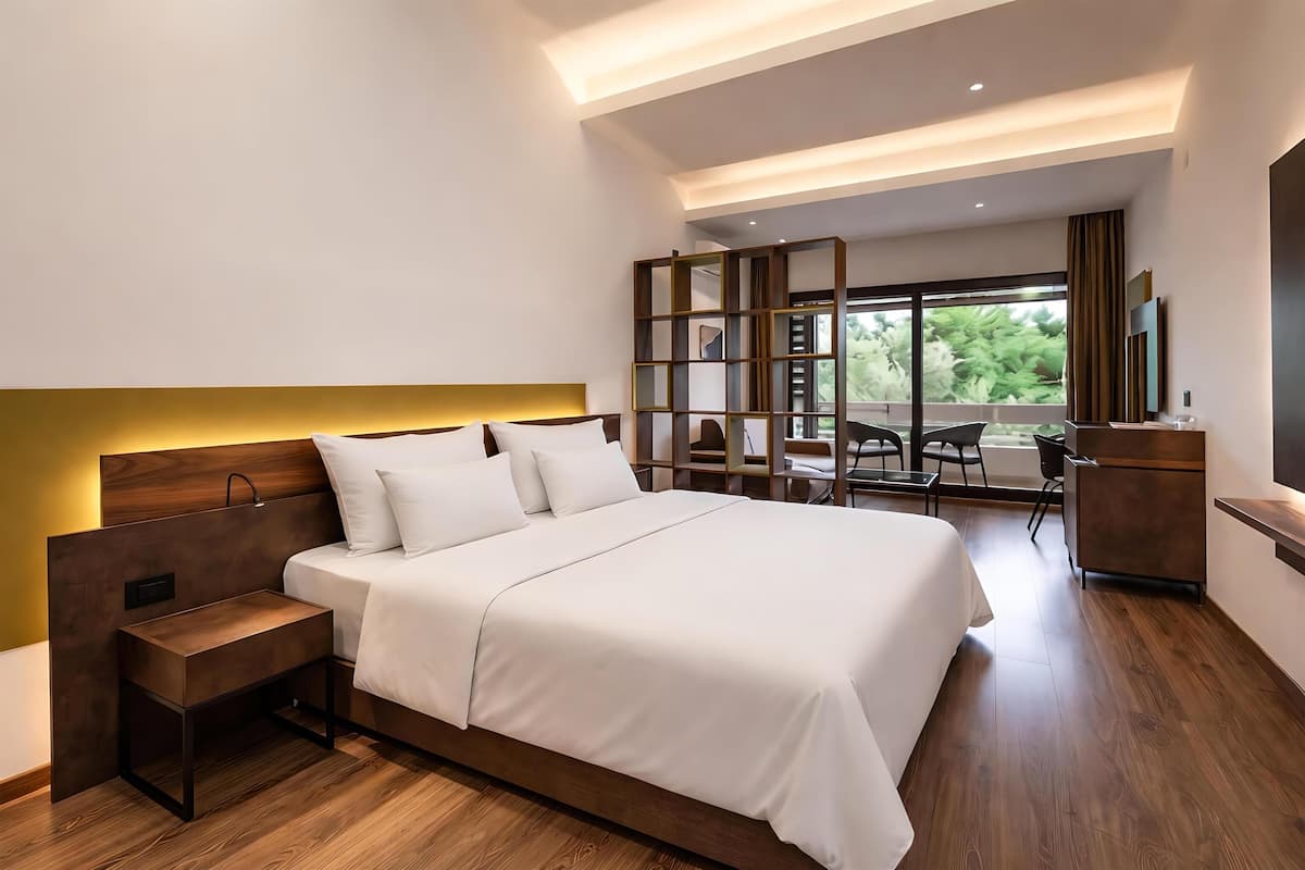 Une chambre moderne avec un grand lit, une table de chevet et une vue sur l’extérieur.