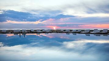 Alberca al aire libre, sombrillas en la alberca y camastros