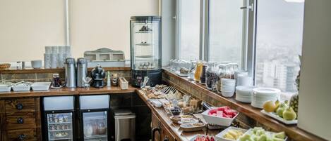 A buffet setup with various food items and a refrigerator.