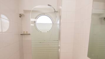 A modern bathroom with a glass-enclosed shower, a toilet, and a wooden floor.