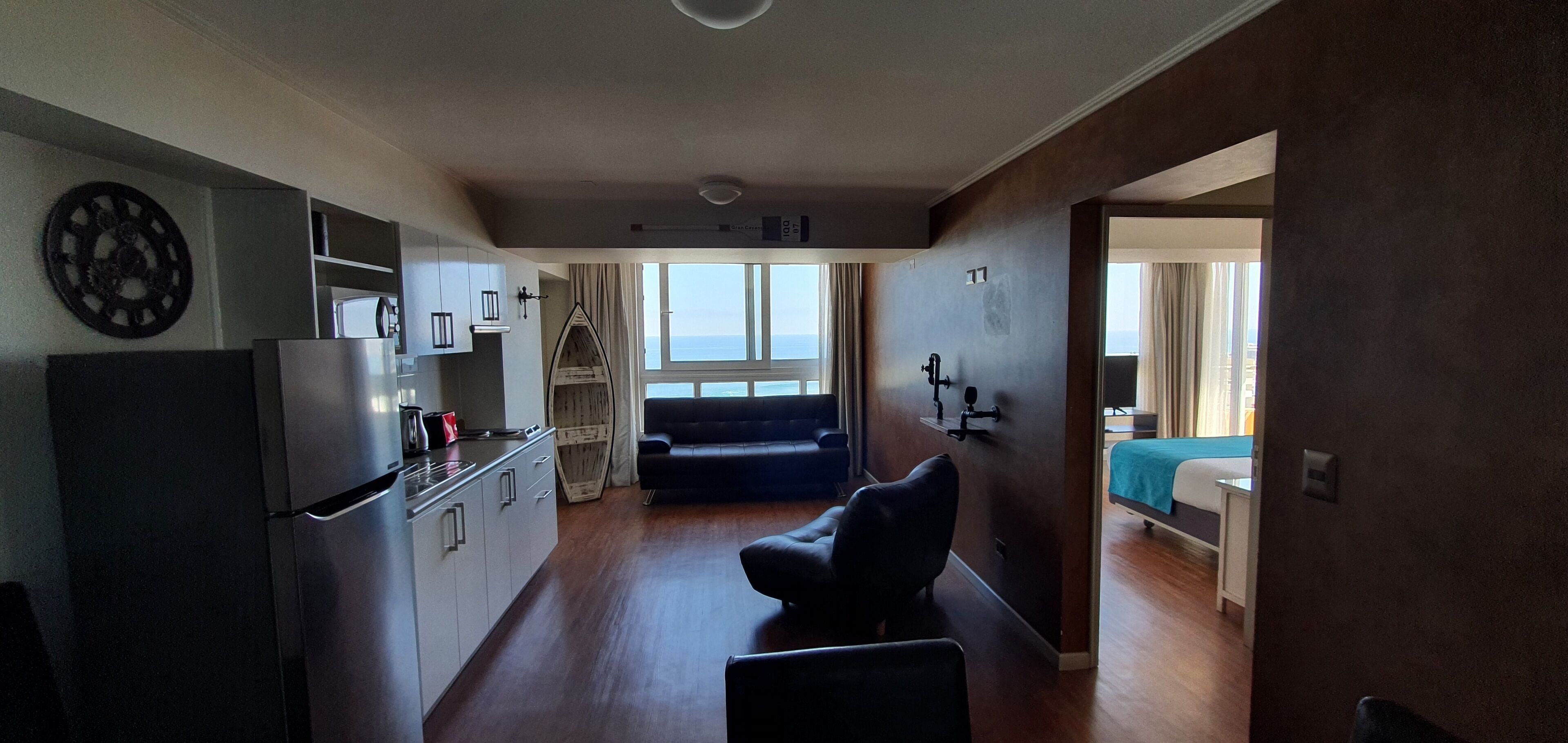 A compact living space with a kitchenette, a sofa, and a bed.
