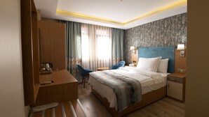 A hotel room with a bed, bedside table, lamp, chair, desk, and curtains. - Hotel Devman (Istanbul)