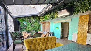 A modern indoor space with a green wall, a dining table, and several chairs. - Hotel Devman (Istanbul)