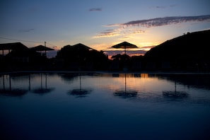 Una piscina al aire libre de temporada, sombrillas