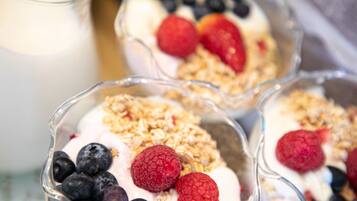 Three bowls of yogurt topped with granola and berries.