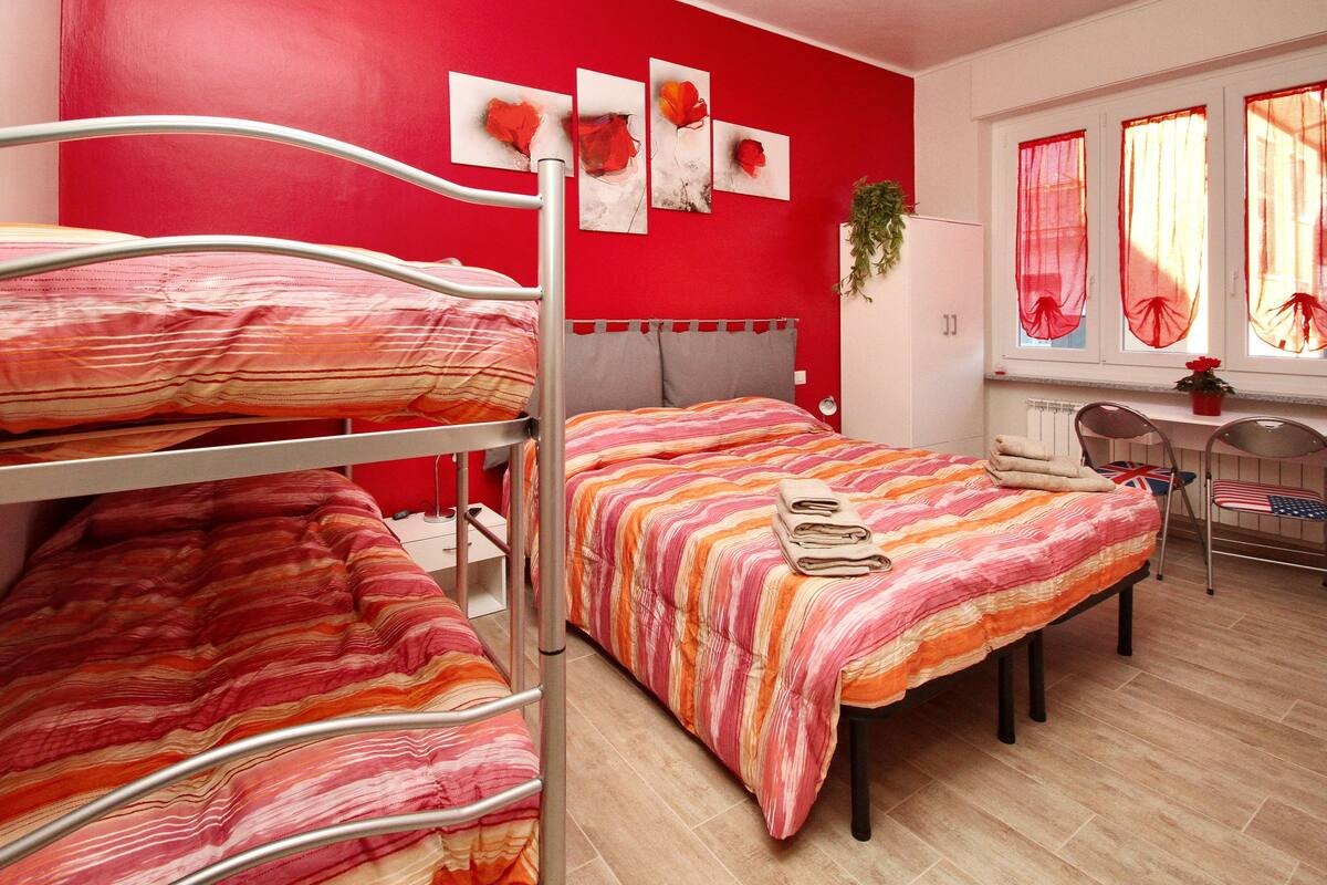 Ein Schlafsaalzimmer mit Etagenbetten, einem Schreibtisch und einem Stuhl.