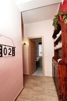 Un pasillo con un armario de madera, un reloj de pared y una puerta que da a otra habitación.