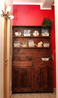 Un mueble de madera con varios estantes, cada uno con libros y objetos decorativos.