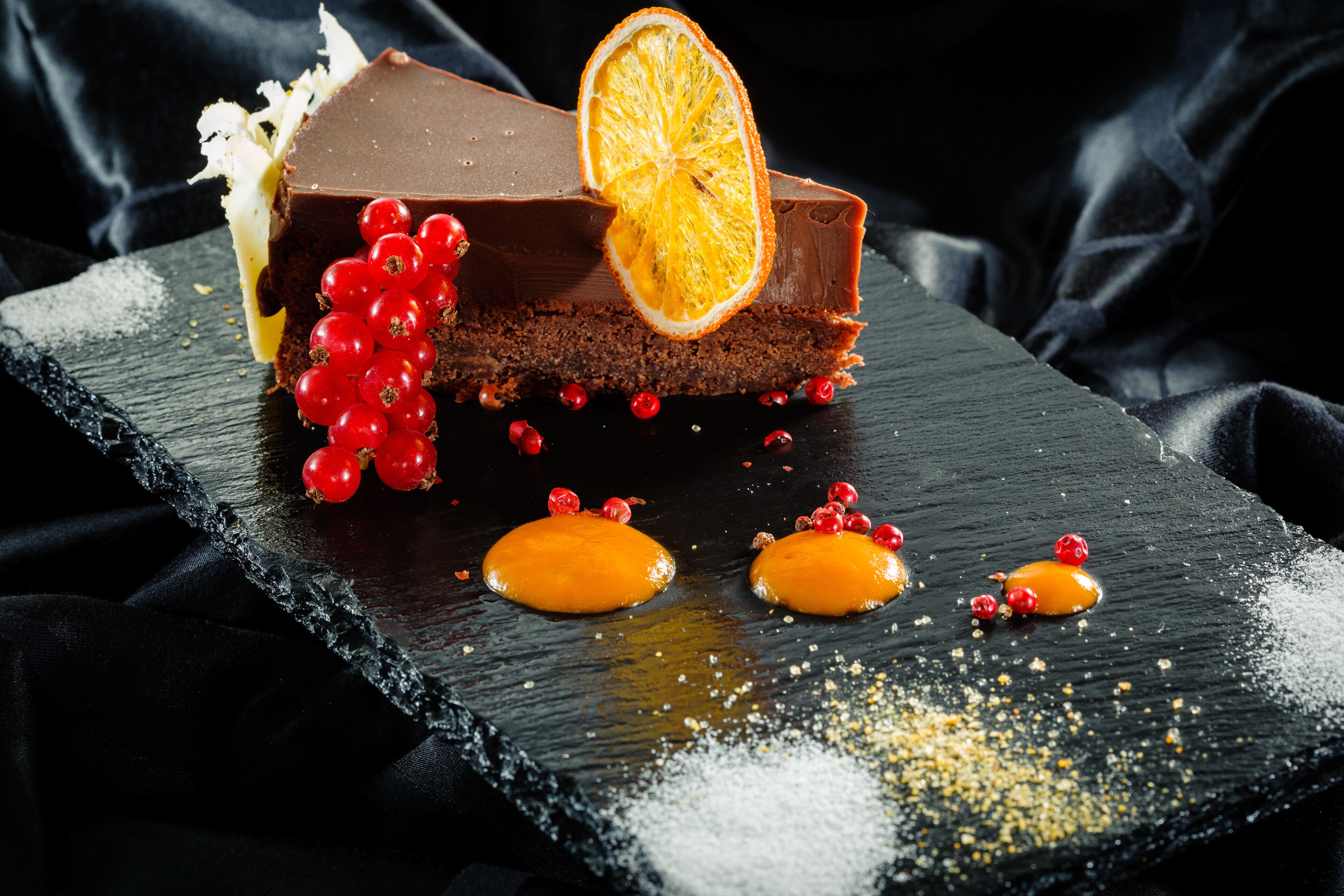 Un postre sobre una tabla de pizarra con fondo oscuro.