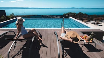 Inomhuspool, en säsongsöppen utomhuspool, parasoller och solstolar