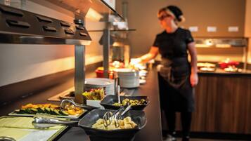 A buffet setup with various dishes and serving utensils.