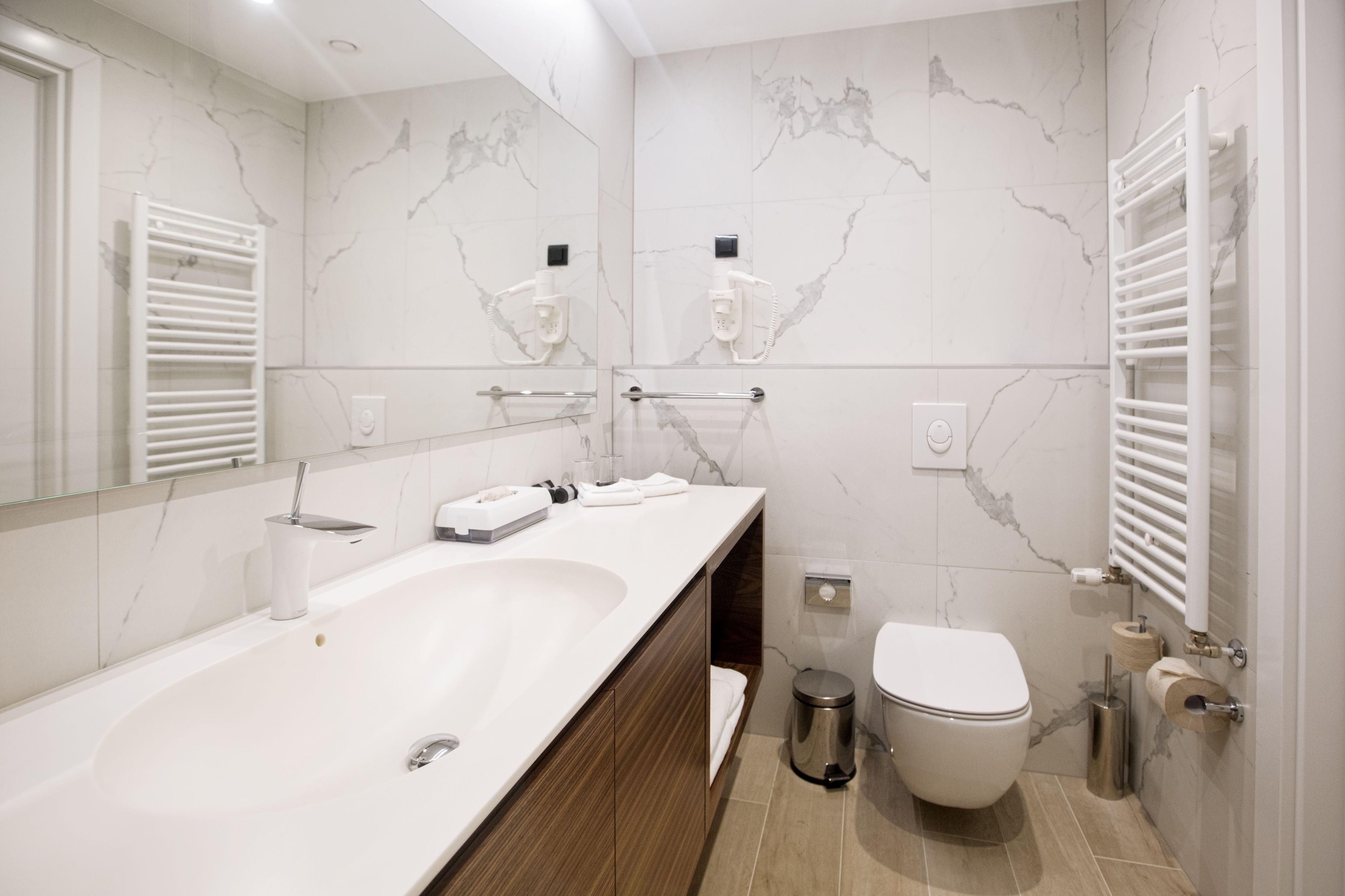 A modern bathroom with a large bathtub, a toilet, and a sink.