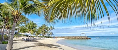 شاطئ خاص، رمال بيضاء، كراسي للتشمس، مظلات الشاطئ