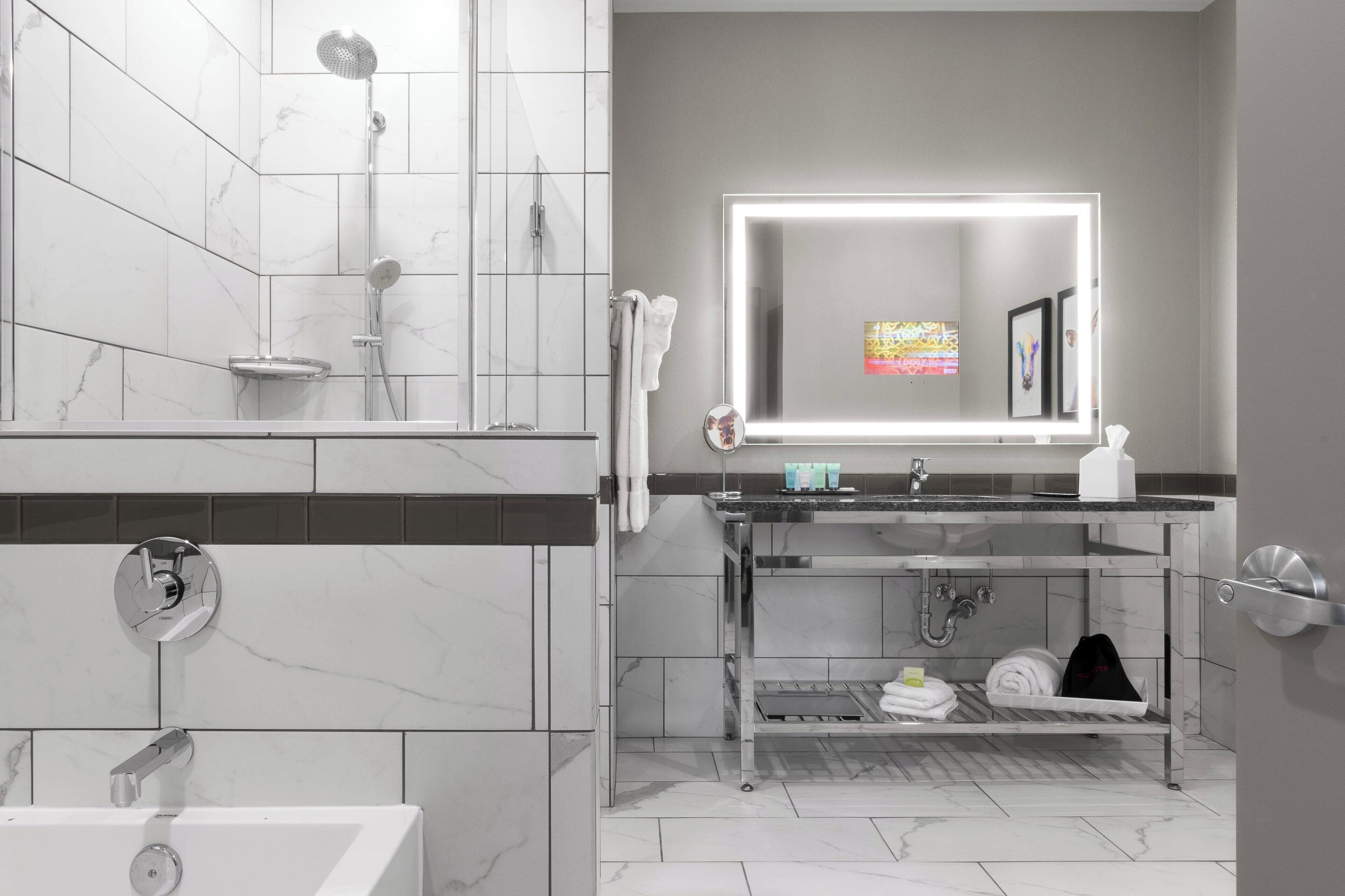 A modern bathroom with a shower, a sink with a mirror, and a towel rack.