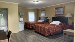 A hotel room with two beds, a desk, a chair, a lamp, and a ceiling fan. - Dunlop Motel (Ashfield-Colborne-Wawanosh)