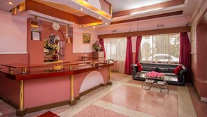 A reception area with a reception desk, a sofa, and a coffee table. - Chester Hotel (Nakuru)