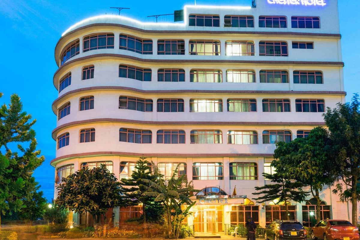 Un hôtel à plusieurs étages, doté d’une façade incurvée, de nombreux balcons et d’une entrée bien éclairée.