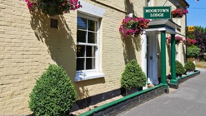 A traditional building with a sign reading "MOORTOWN LODGE." - Moortown Lodge 1760 (Ringwood)