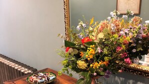 A wooden dresser with a vase of flowers and a bowl of chocolates. - Moortown Lodge 1760 (Ringwood)