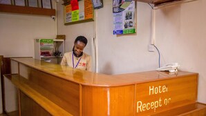 Een receptiebalie van een hotel, met een bordje met daarop 'Hotel Receptie'.