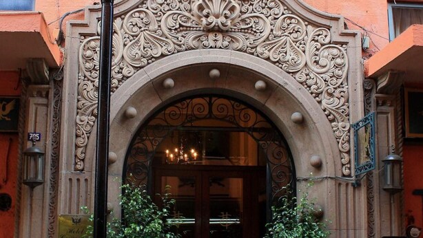 An ornate entrance with a large archway, two potted plants, and a street lamp. - Gran Hotel Concordia San Luis Potosí (San Luis Potosi)