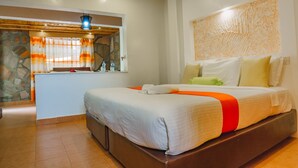A hotel room with a large bed, a small desk, and a stone wall. - Sahara Gardens Kericho (Kericho)
