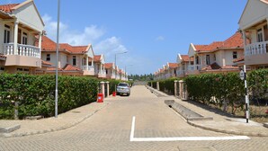 A residential street with houses, a paved road, and a parked car. - Azanza Mtwapa Holiday Home (Mtwapa)