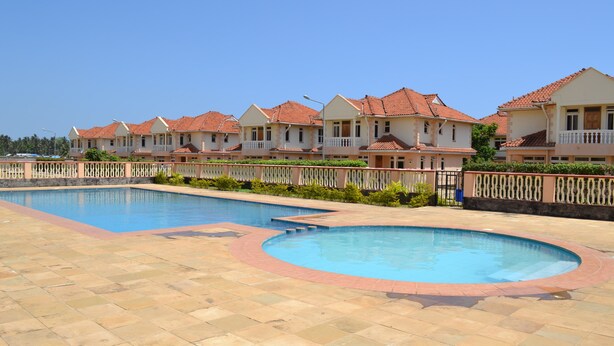A resort with multiple swimming pools and a row of villas with red-tiled roofs. - Azanza Mtwapa Holiday Home (Mtwapa)