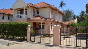 A two-story house with a balcony, a gated entrance, and a number '44' sign. - Azanza Mtwapa Holiday Home (Mtwapa)