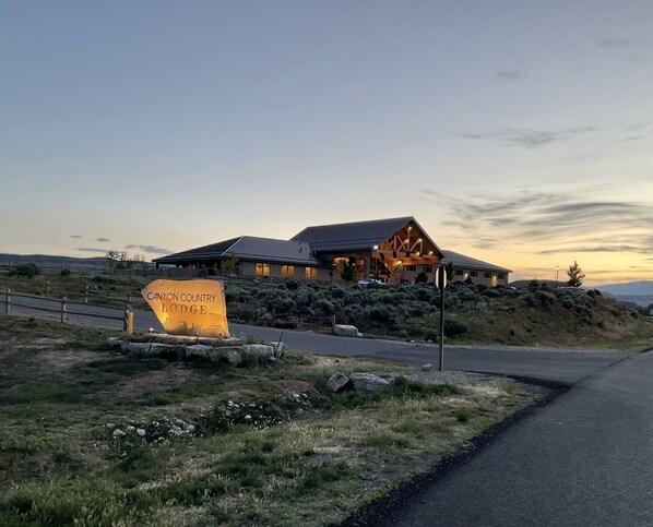 A lodge with a prominent sign reading "Canyon Country Lodge" in a natural setting with a road leading to it. - Canyon Country Lodge (Escalante)