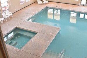 A pool with a separate hot tub area, lounge chairs, and a clear view of the pool's edge. - Canyon Country Lodge (Escalante)