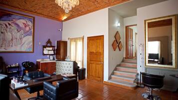 Un salón con techo de madera, un espejo grande y una escalera que sube a otro nivel.