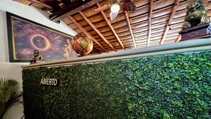 A reception area with a green wall, a ceiling fan, and a framed artwork above the wall. - Hacienda del Lago Boutique Hotel (Ajijic)