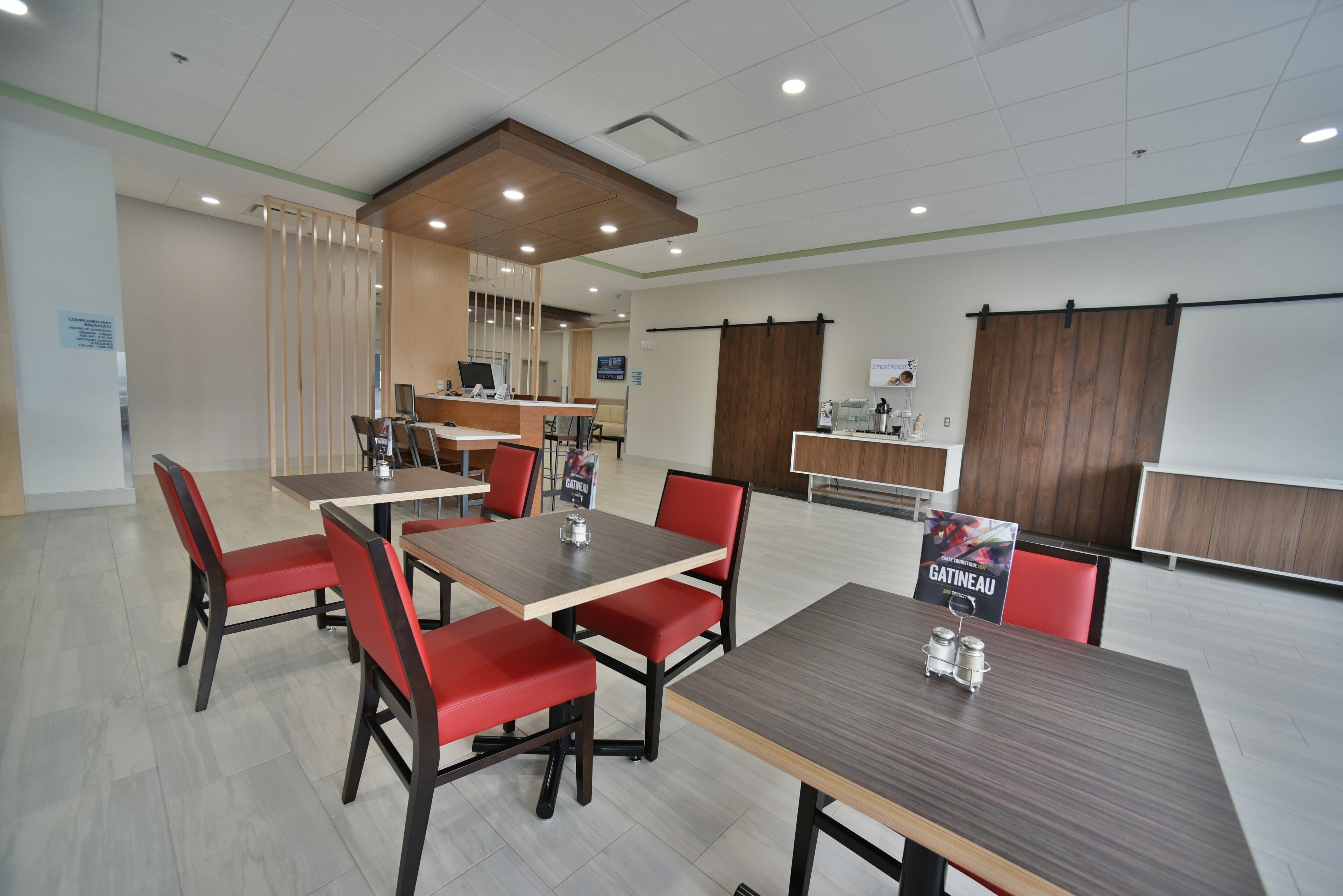 A conference room with a long table and red chairs, a reception desk, and a whiteboard.