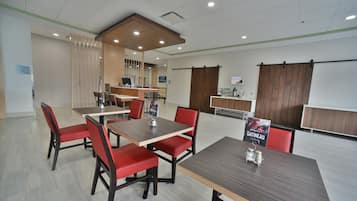 A conference room with a long table and red chairs, a reception desk, and a whiteboard.