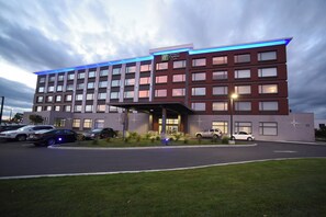 A Holiday Inn Express hotel with a modern design, featuring a large parking lot and a well-maintained lawn. - Holiday Inn Express & Suites - Gatineau - Ottawa by IHG (Gatineau)