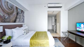 Ein modernes Hotelzimmer mit einem ordentlich bezogenen Bett, einem Flachbildfernseher und einem großen, abstrakten Gemälde an der Wand.