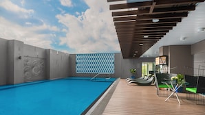 Une piscine intérieure dotée d’une terrasse en bois, d’une fresque représentant des vélos et d’un mur orné de motifs.