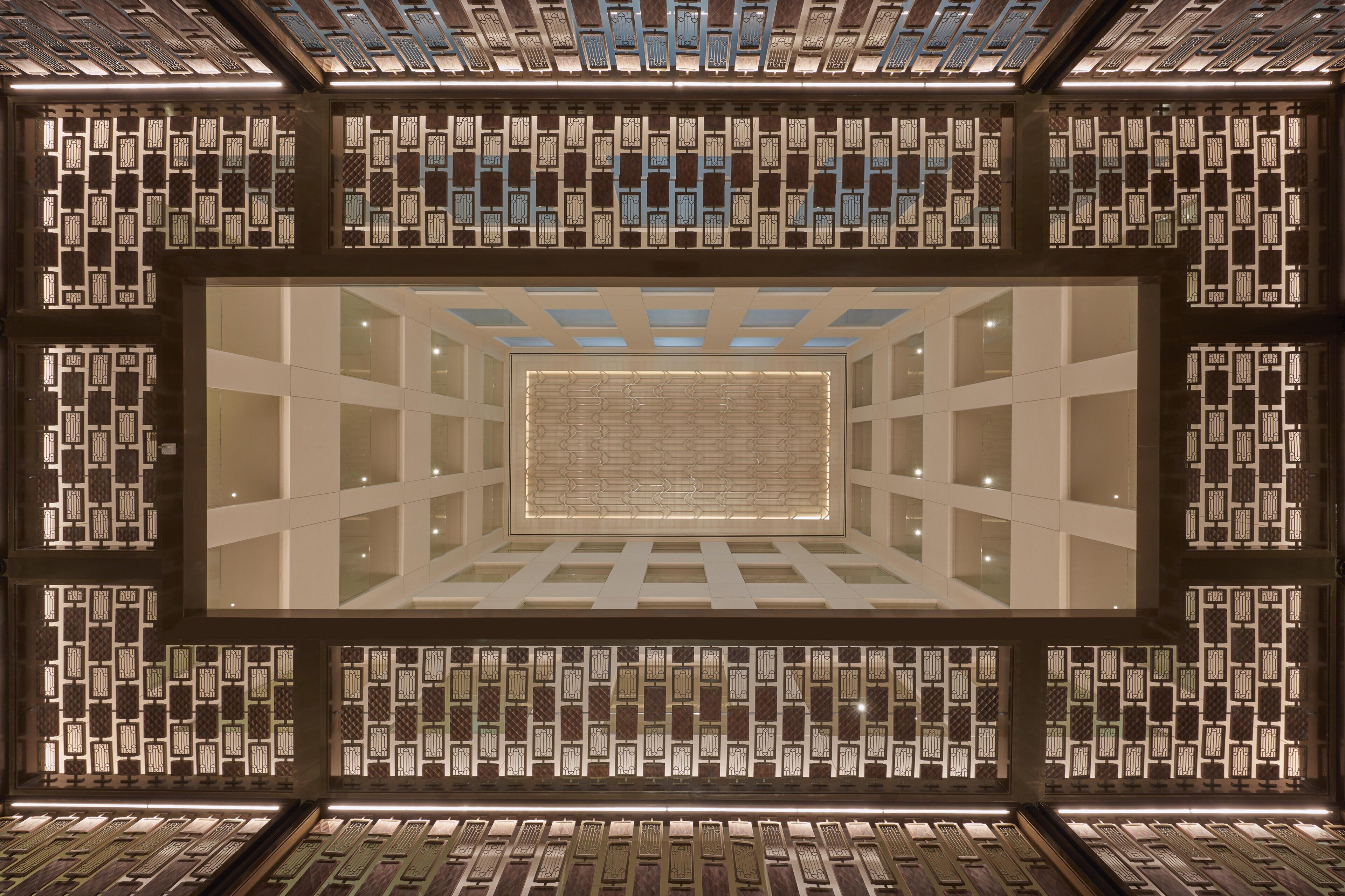 A modern interior with a central rectangular skylight surrounded by patterned walls.