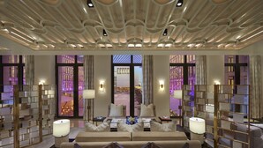 A hotel room with a large bed, two side tables with lamps, a view of a cityscape through large windows, and a decorative ceiling. - Mandarin Oriental, Doha (Doha)