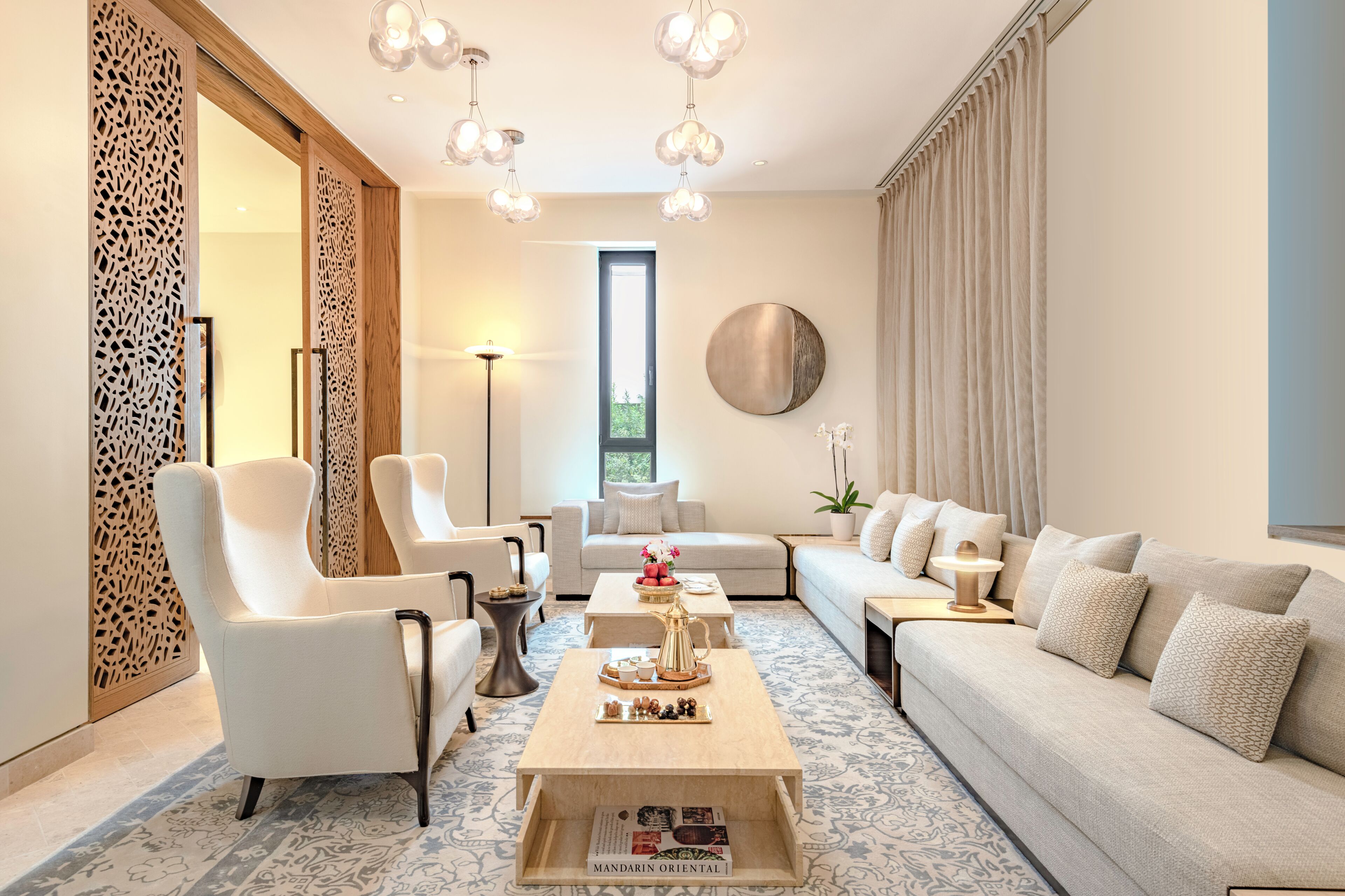 Ein modernes Wohnzimmer mit einer Couch, Sesseln, einem Couchtisch und einer Wanddekoration.