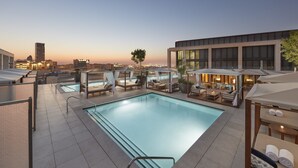 A rooftop pool area with lounge chairs and umbrellas, surrounded by modern buildings and a clear sky. - Mandarin Oriental, Doha (Doha)