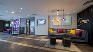 A modern lobby with a sofa, armchairs, a TV, and a reception desk. - Premier Inn Leeds Cc - Whitehall Road (Leeds)
