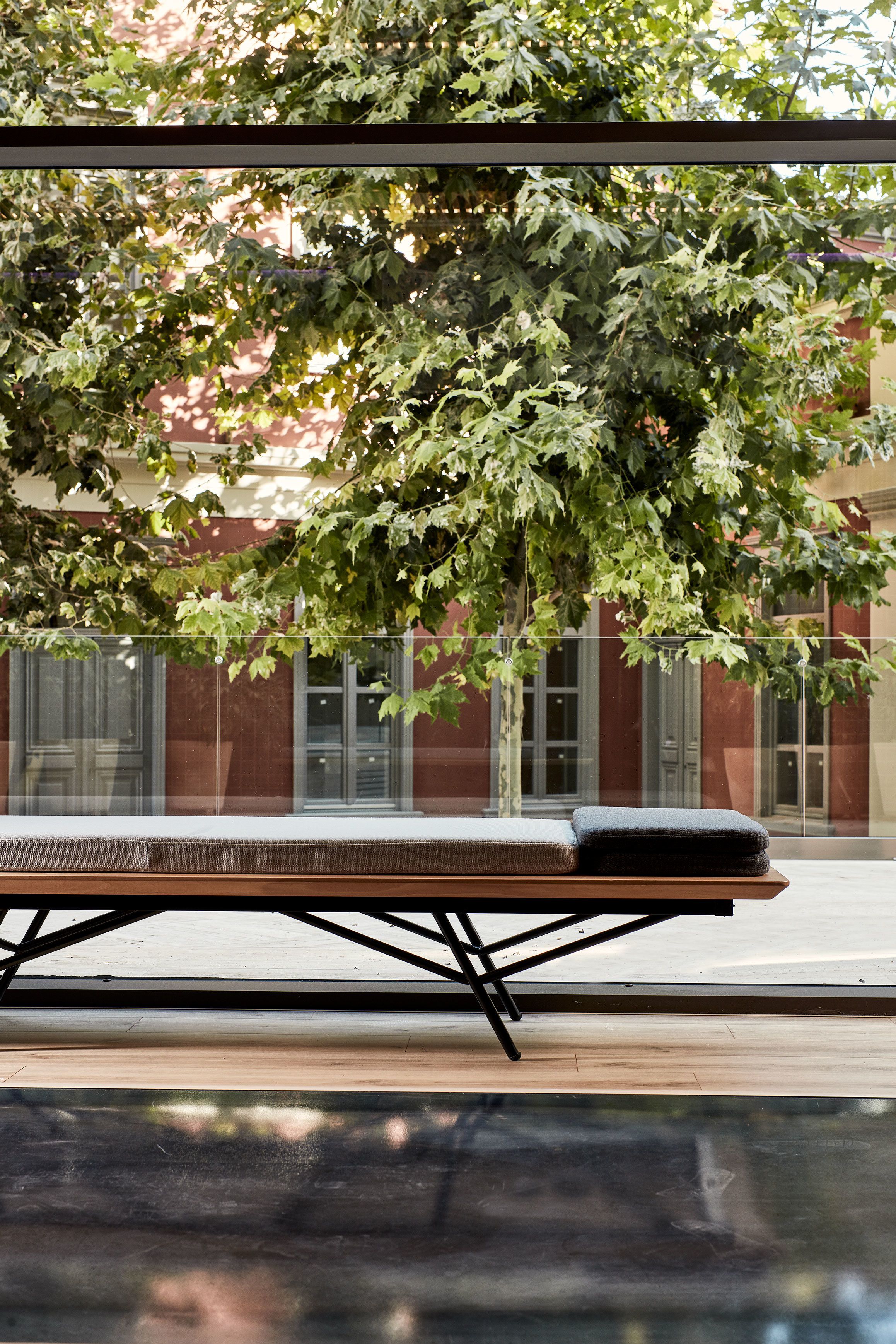 Un espace de détente moderne, doté d’un banc et d’une cloison en verre.